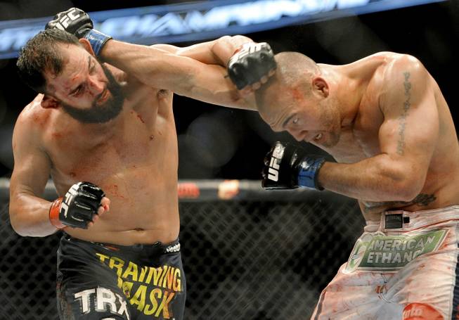 Johny Hendricks, left, and Robbie Lawler exchange punches during a UFC 171 mixed martial arts welterweight title bout, Saturday, March 15, 2014, in Dallas. Hendricks won by decision.